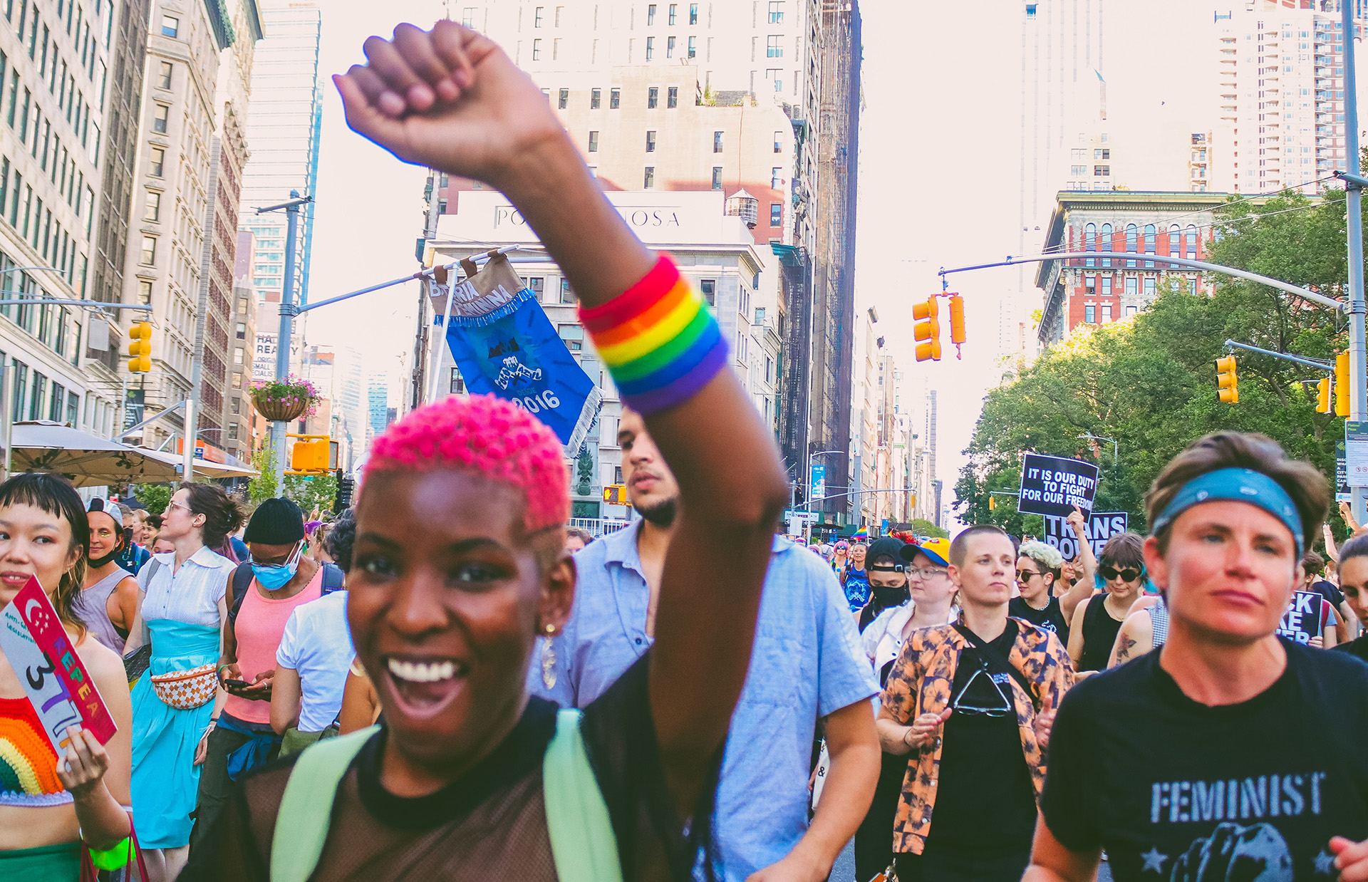 black woman with rainbow wristband at march